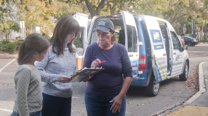 Heather Hough (center) and her daughter Sonia Batista confer with MOW Yolo’s Davis Meal Connection Coordinator Tina Gonzales before departing on a meal delivery route. In addition to volunteering her time, Hough and her partner Bobby Batista also help support the organization through financial giving. Photo by Anne Stokes