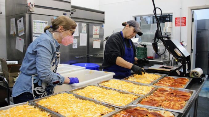 Meals on Wheels Yolo County Food Services Manager Michele Long (right) prepares a meal alongside volunteer Lynne Secrist at the Meals on Wheels-Sutter Health Senior Nutrition Center in Winters. Photo by Alyssa Branum